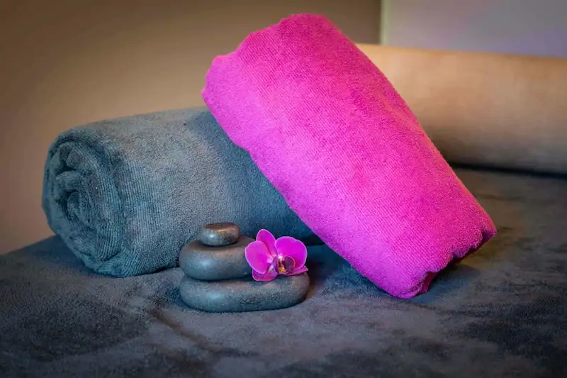 Handoek, stenen en bloem op massage bed